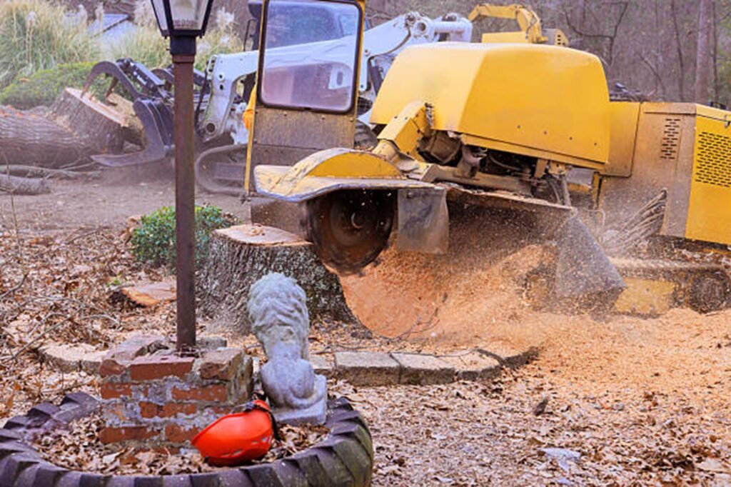Stump grinding machine removing a large tree stump and wood debris in a residential yard in Macedonia, OH