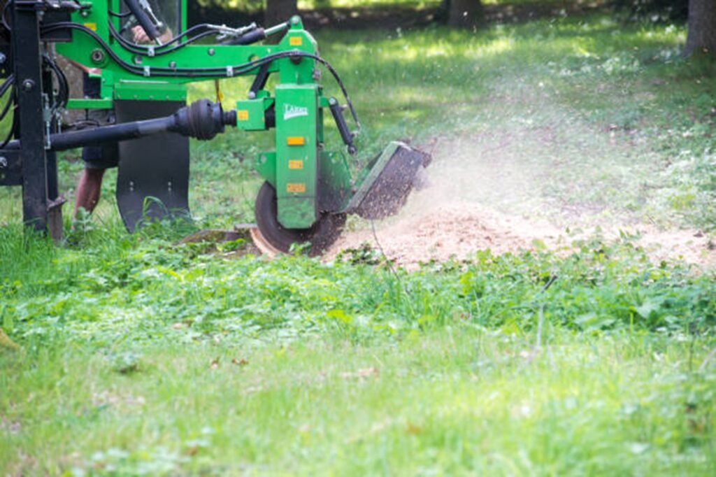Stump grinding machine removing a tree stump and wood chips in a residential yard in Macedonia, OH